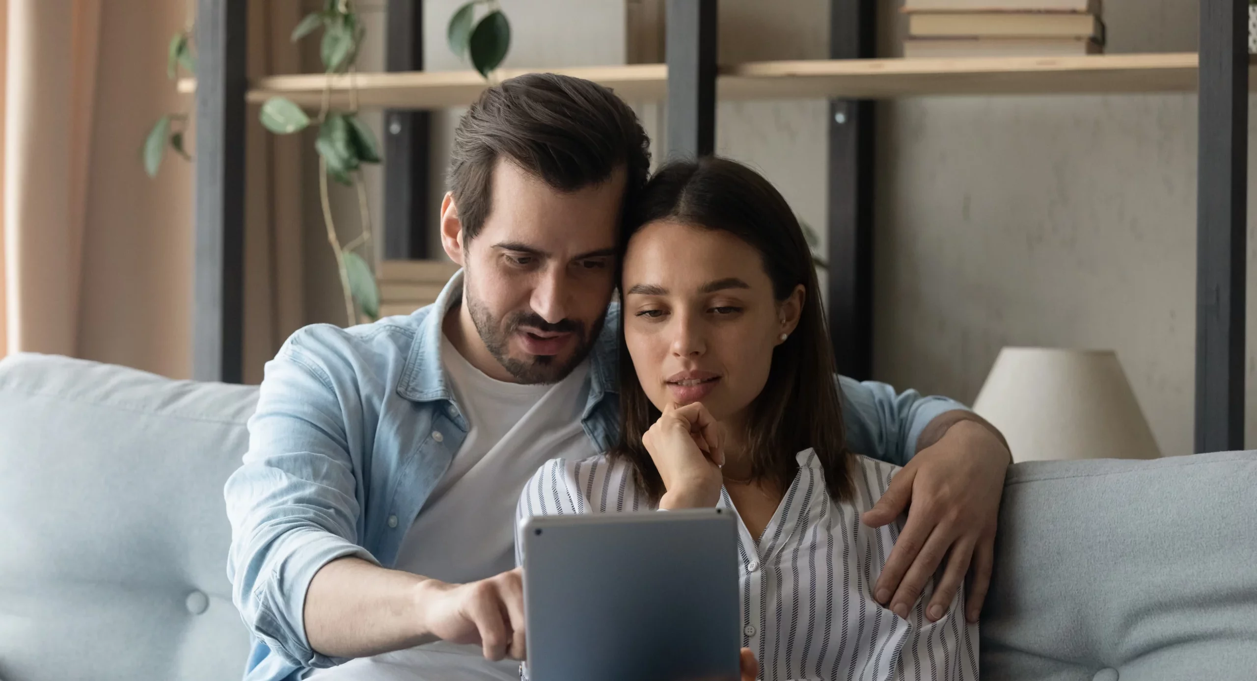 a couple is reviewing their energy budget on a tablet device