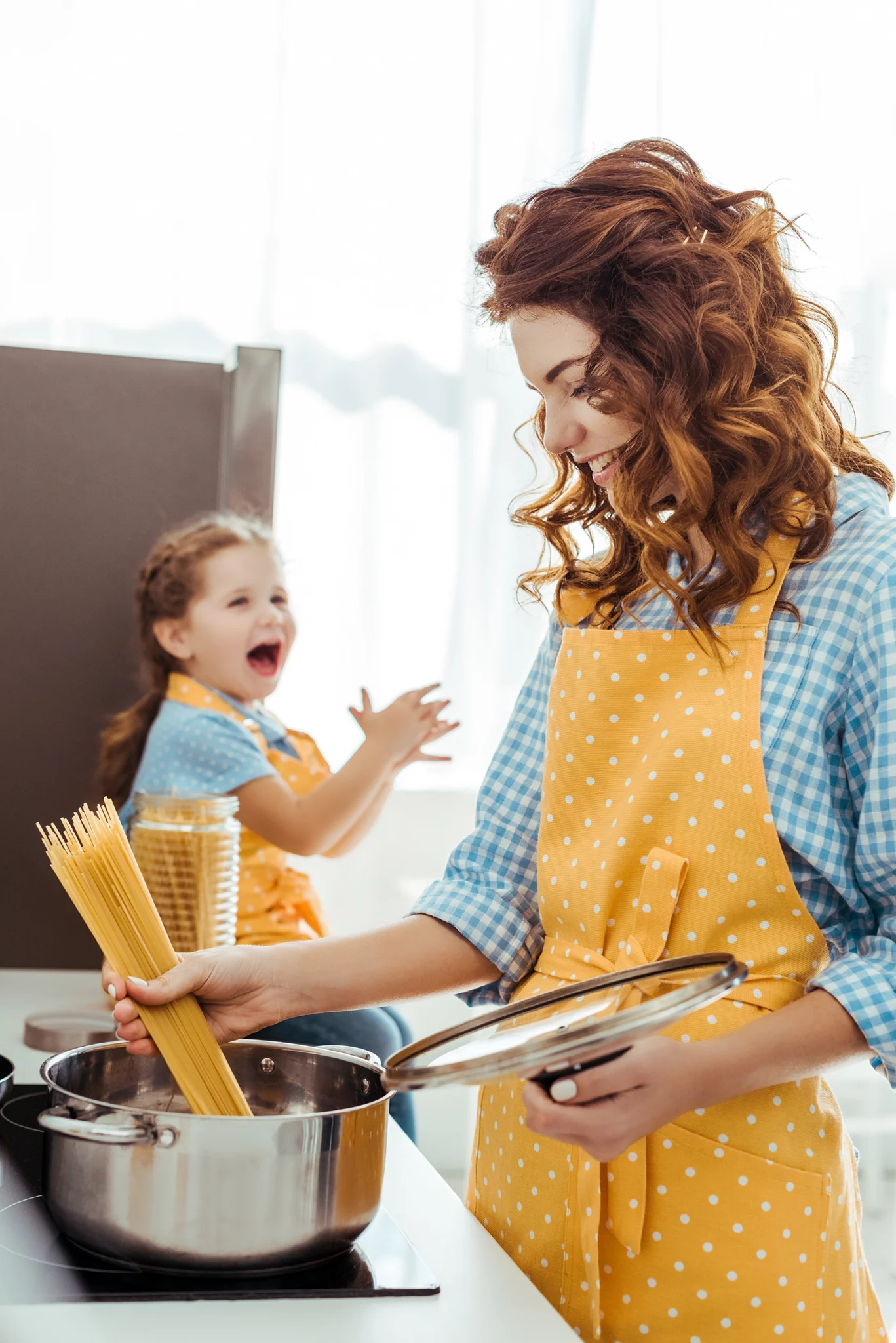 mom and daughter cooking in kitchen