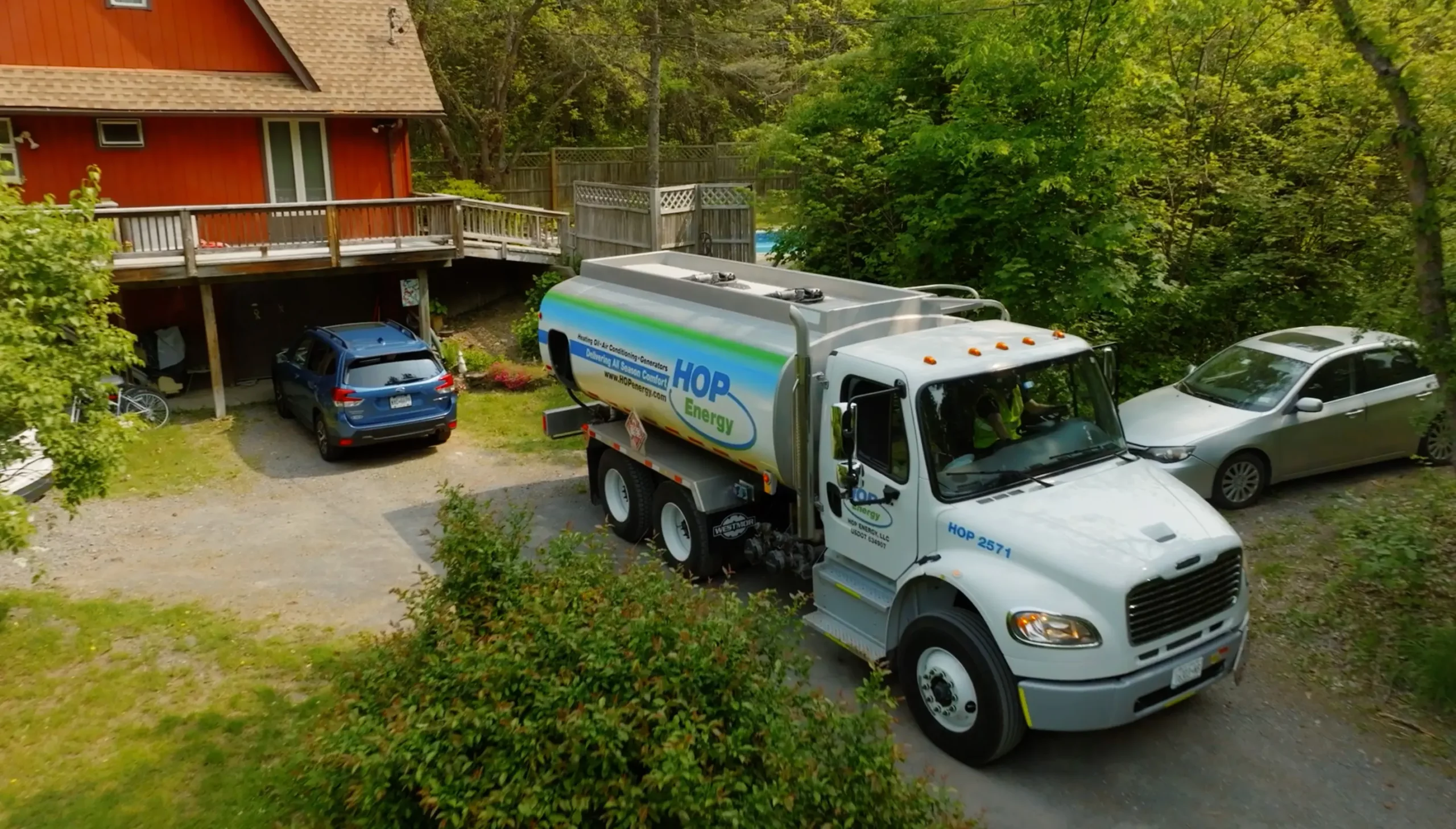 a HOP energy delivery truck is in front of customers home delivering heating oil